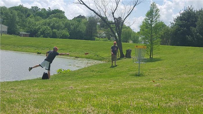 Man Putts Disc to Hole at Litz Park